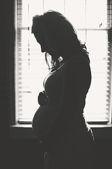 Silhouette of a pregnant lady holding her stomach