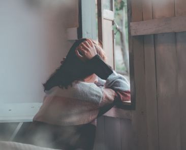 picture of a woman leaning looking out of a window